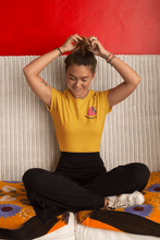 Charger l'image dans la galerie, femme-assise-qui-rigole-et-sattache-les-cheveux-qui-porte-un-tshirt-ohmyfruits-jaune-framboise