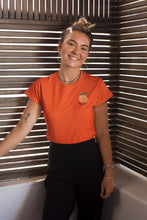 Charger l'image dans la galerie, modele-sublime-femme-qui-porte-un-tshirt-orange-peche-ohmyfruits-et-quipose-dans-un-escalier-blanc-avec-le-ciel-bleumannequin-ravissante-femme-qui-sourit-et-qui-porte-un-tshirt-peche-orange-ohmyfruits-dans-une-piece-en-bois