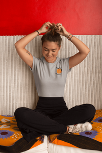 femme-assise-qui-rigole-et-sattache-les-cheveux-qui-porte-un-tshirt-ohmyfruits-gris-mandarine