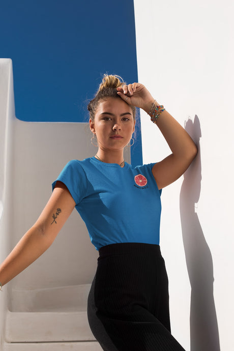 modele-sublime-femme-qui-porte-un-tshirt-bleu-pamplemousse-ohmyfruits-et-quipose-dans-un-escalier-blanc-avec-le-ciel-bleu