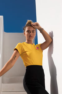 modele-sublime-femme-qui-porte-un-tshirt-jaune-framboise-ohmyfruits-et-quipose-dans-un-escalier-blanc-avec-le-ciel-bleu