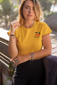 femme-qui-pose-pour-ohmyfruits-avec-un-tshirt-jaune-et-un-fruit-mandarine