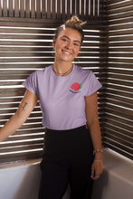 Charger l&#39;image dans la galerie, mannequin-ravissante-femme-qui-sourit-et-qui-porte-un-tshirt-fraise-lavande-ohmyfruits-dans-une-piece-en-bois
